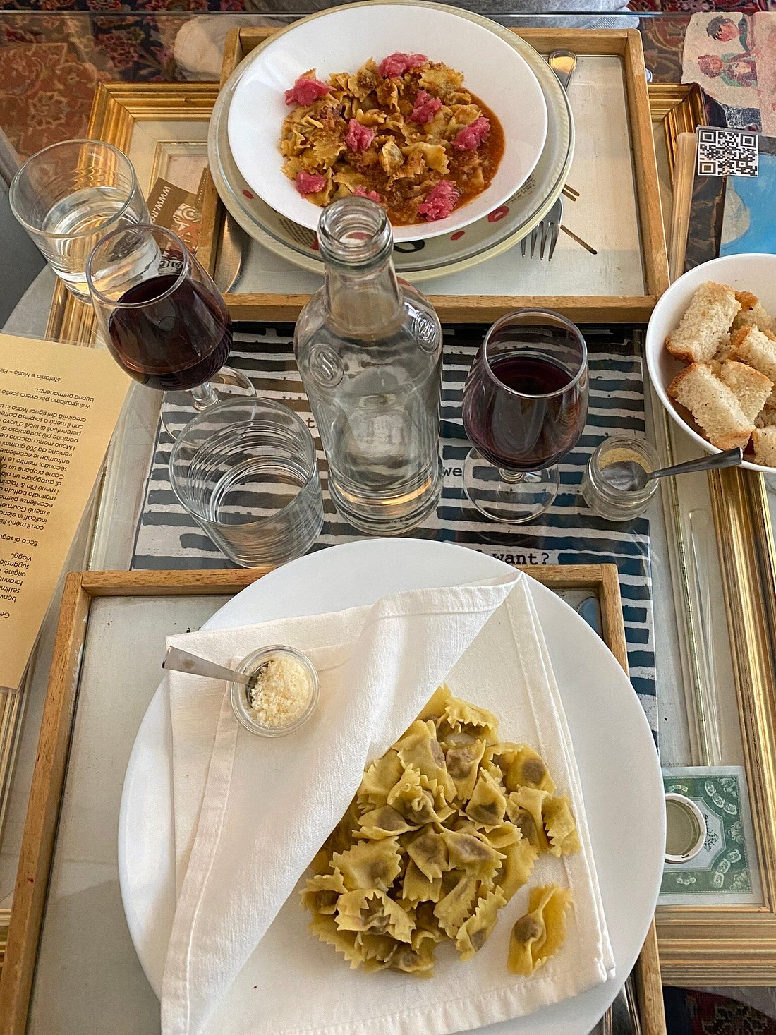 Table set with pasta dishes and red wine