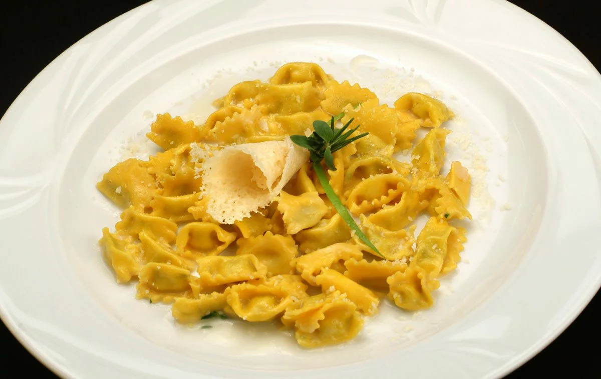 Handmade plin pasta on white plate